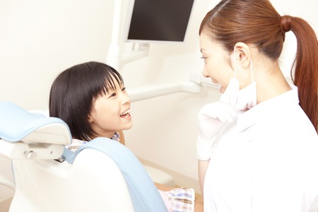 Dental hygienist to talk to girls of patientの写真素材