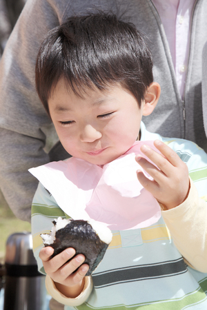 Boy to stuff oneself rice ballsの写真素材