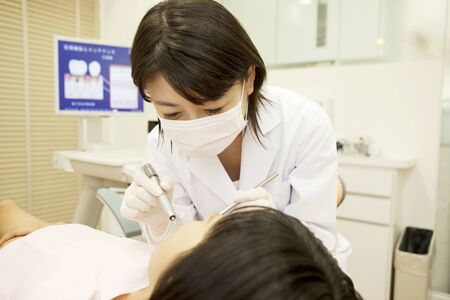 Woman dentist, except for in the girl's mouthの写真素材
