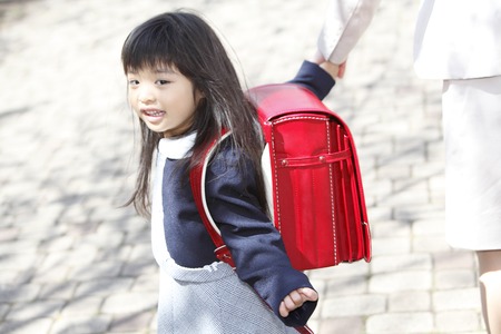 Elementary school students walk by connecting the mother and hand girlsの写真素材