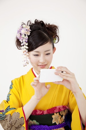 Women kimono figure to operate the smart phoneの写真素材