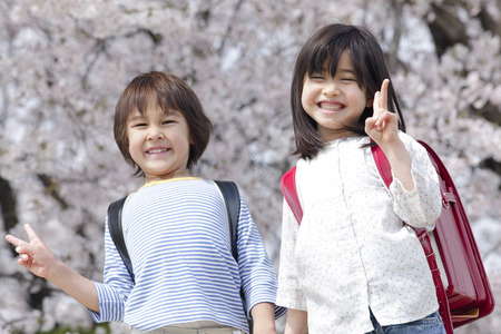 Elementary school students to the peace sign hand in handの写真素材