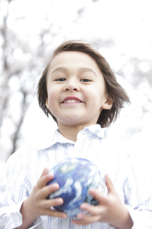 Boy smiling with a globeの写真素材
