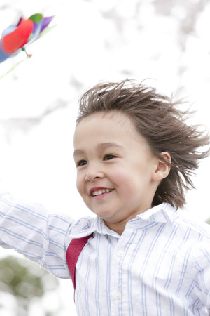 Boy running with a windmillの写真素材