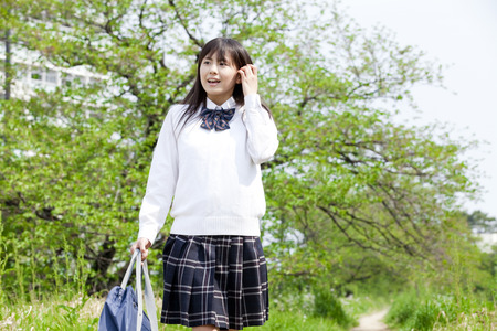 Female high school students walk the footpathの写真素材