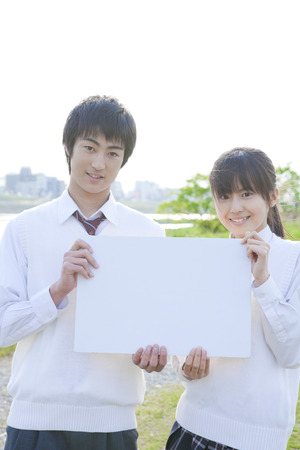 High school couple with message boardの写真素材