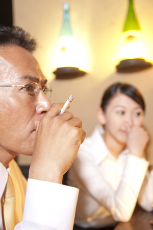 OL to be sensitive to smoke and businessman smokeの写真素材