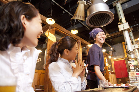Women who rejoice with the clerk carrying the cuisineの写真素材