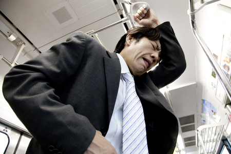 Businessman to cause abdominal pain on a trainの写真素材