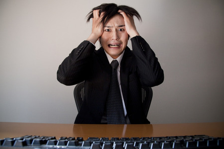 Businessmen hold their head in front of the PCの写真素材