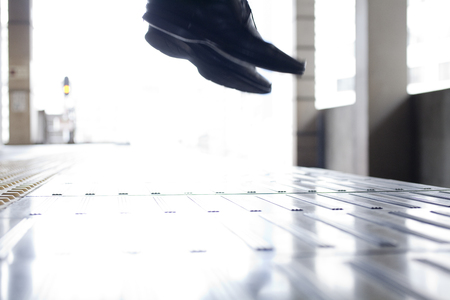 Feet of businessmen jumping into the lineの写真素材