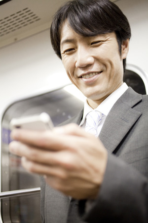 Businessman smiling with a smartphoneの写真素材