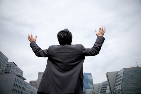 Back shot of businessman pointing the skyの写真素材