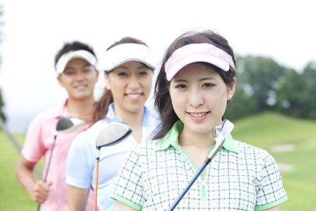 Men and women smiling with a golf clubの写真素材