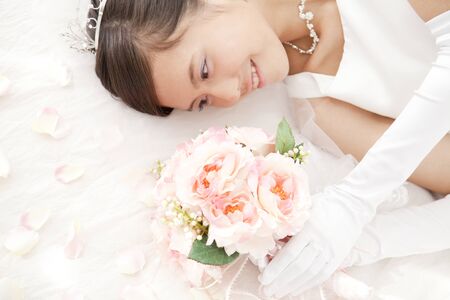 Bride to lie down with a bouquetの写真素材