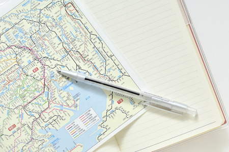 Notebook and ballpoint pens and mapsの写真素材