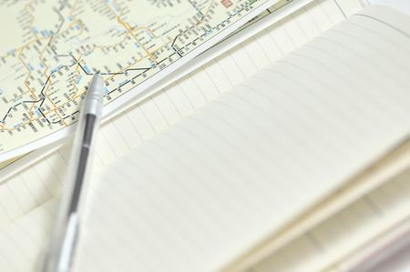 Notebook and ballpoint pens and mapsの写真素材