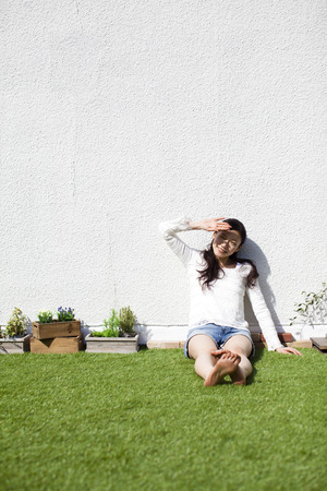 Woman sitting on the lawnの写真素材