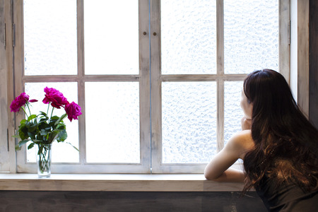 Woman sitting by the window of the chairの写真素材