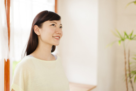Woman standing at a windowの写真素材