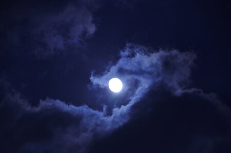Moon behind the cloudsの写真素材