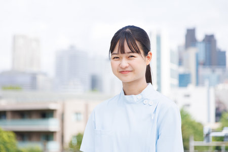 Asian teenage girl in nurse uniform looking at the cameraの写真素材