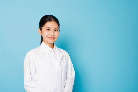 Portrait of Asian teenage girl in lab coatの写真素材