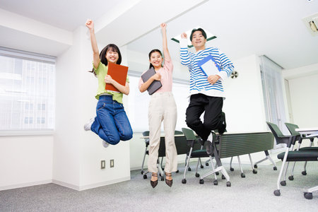 Portrait of Asian teenagers jumping togetherの写真素材
