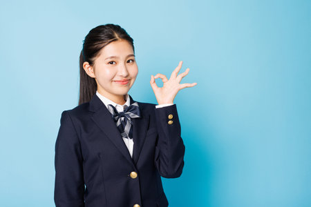 Asian teenage girl in high school uniform posing for the cameraの写真素材