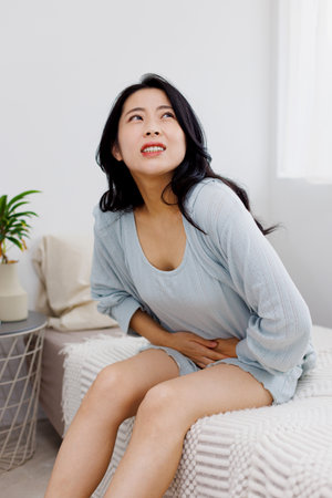 Asian woman suffering from abdominal painの写真素材
