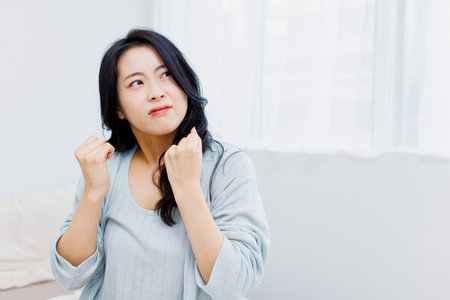 Stressed Asian woman in her bedroomの写真素材