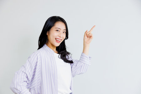 Asian woman with pointing gestureの写真素材
