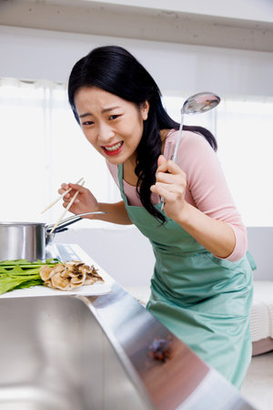 Asian woman shocked to see a cockroach in the kitchenの写真素材