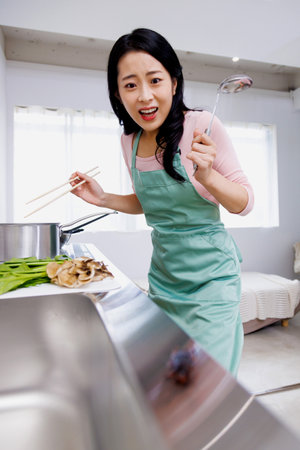 Asian woman shocked to see a cockroach in the kitchenの写真素材