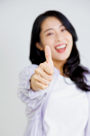 Asian woman with thumbs up gestureの写真素材