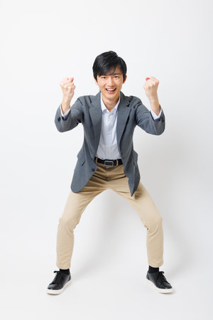 Young Japanese man in office attire with cheering poseの写真素材
