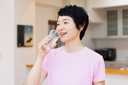 Mature Japanese woman with a glass of waterの写真素材