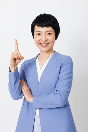 Mature Japanese woman smiling and pointingの写真素材
