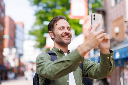 Caucasian man taking picture with mobile phoneの写真素材