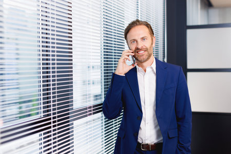 Caucasian man talkin on phone in officeの写真素材