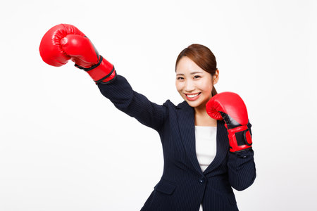 Asian businesswoman posing with fighting glovesの写真素材