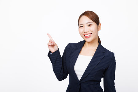 Asian woman in formal wear pointing with fingerの写真素材