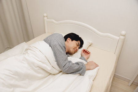 Japanese man sleeping in the bedの写真素材