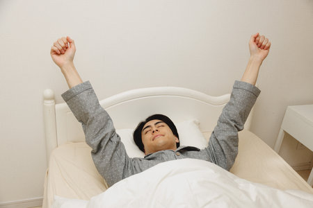 Japanese man get up from bedの写真素材