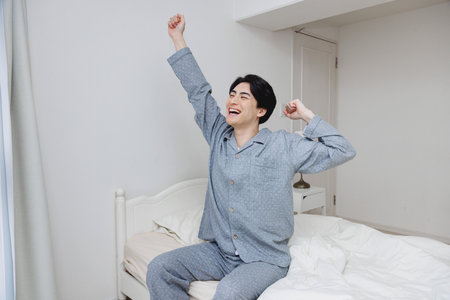 Japanese man get up from bedの写真素材