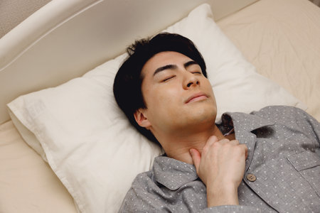 Japanese man sleeping in the bedの写真素材