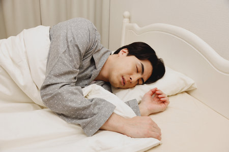 Japanese man sleeping in the bedの写真素材