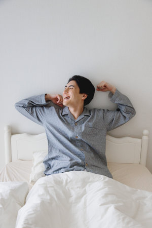 Japanese man get up from bedの写真素材