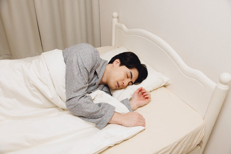 Japanese man sleeping in the bedの写真素材
