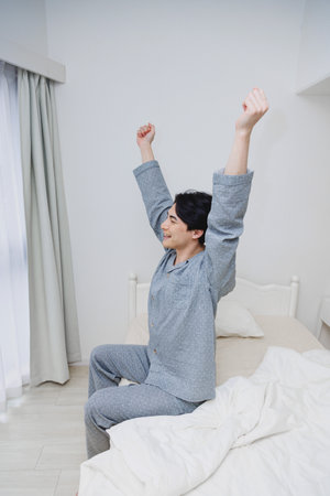 Japanese man get up from bedの写真素材